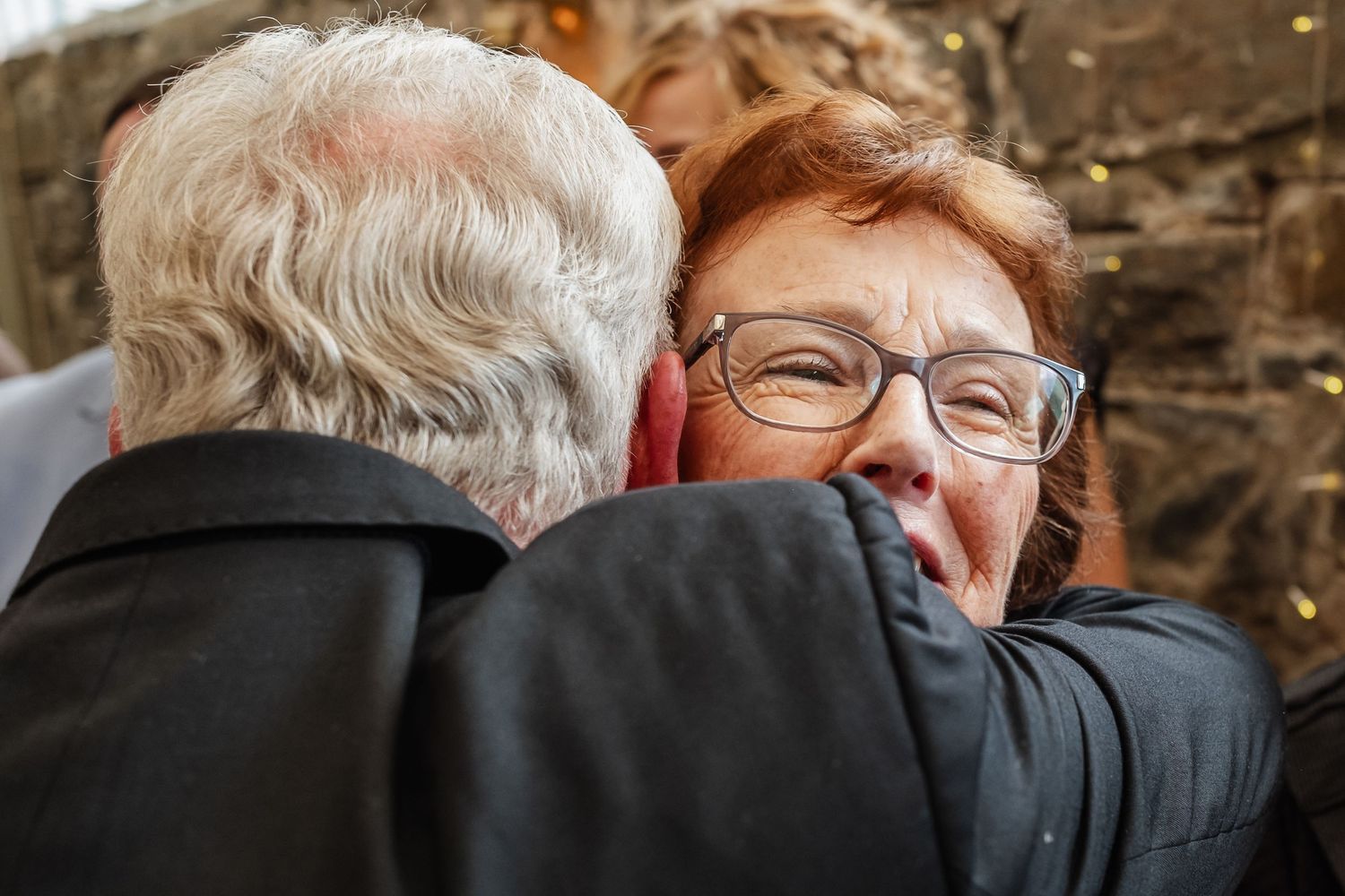 A tender moment of embrace captured during an outdoor celebration.