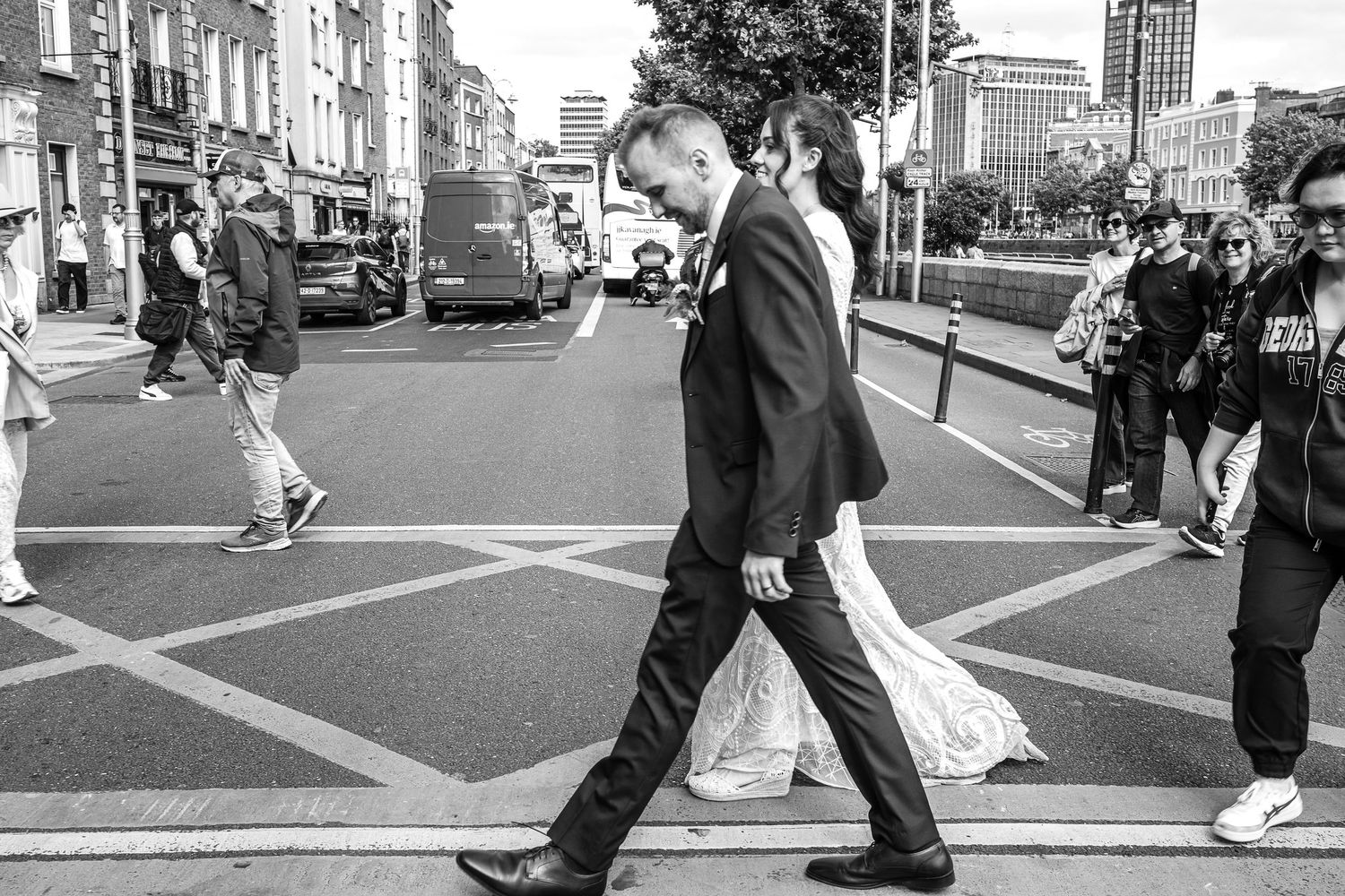 Wedding couple walks together on a city street during their photography session.