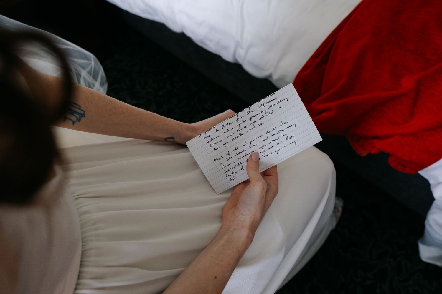 Someone reading handwritten wedding vows from a piece of paper while seated.