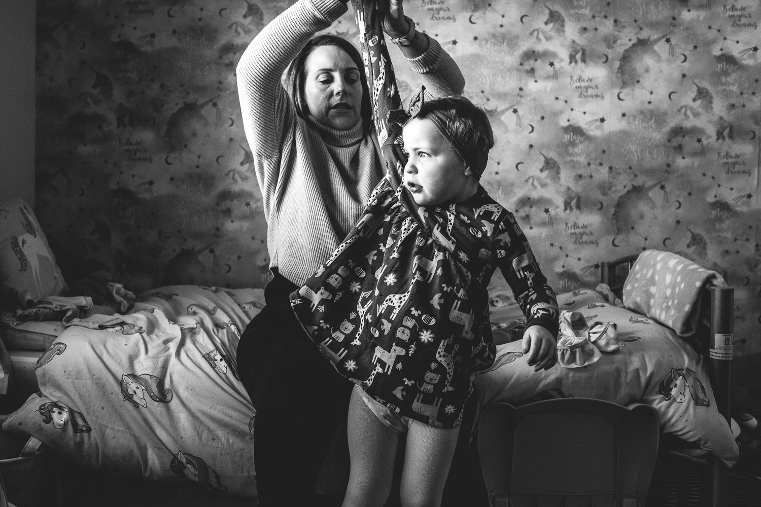 Black and white image of a dance or movement session in a bedroom.
