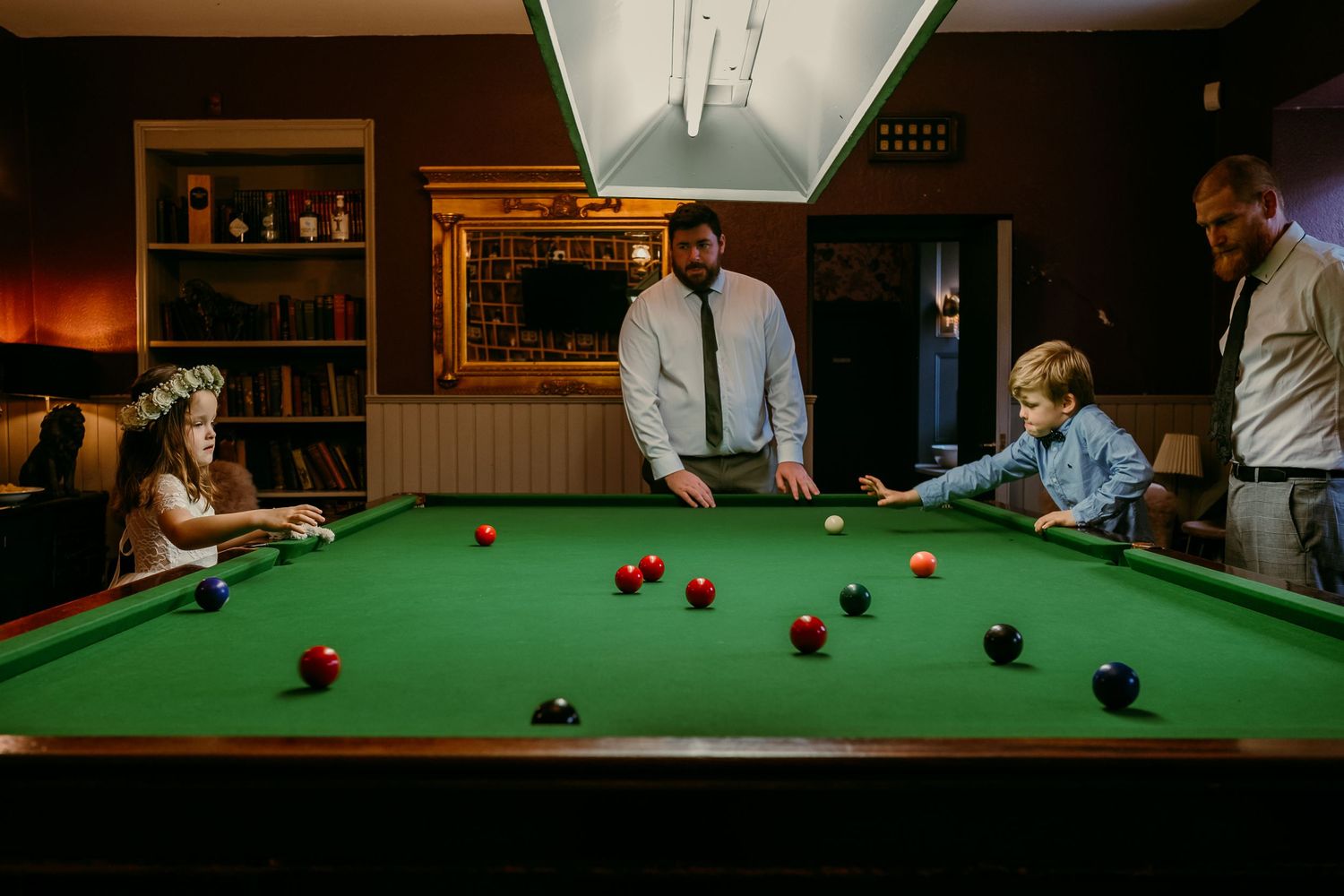 Wedding guests enjoying a game of pool during the reception celebrations.