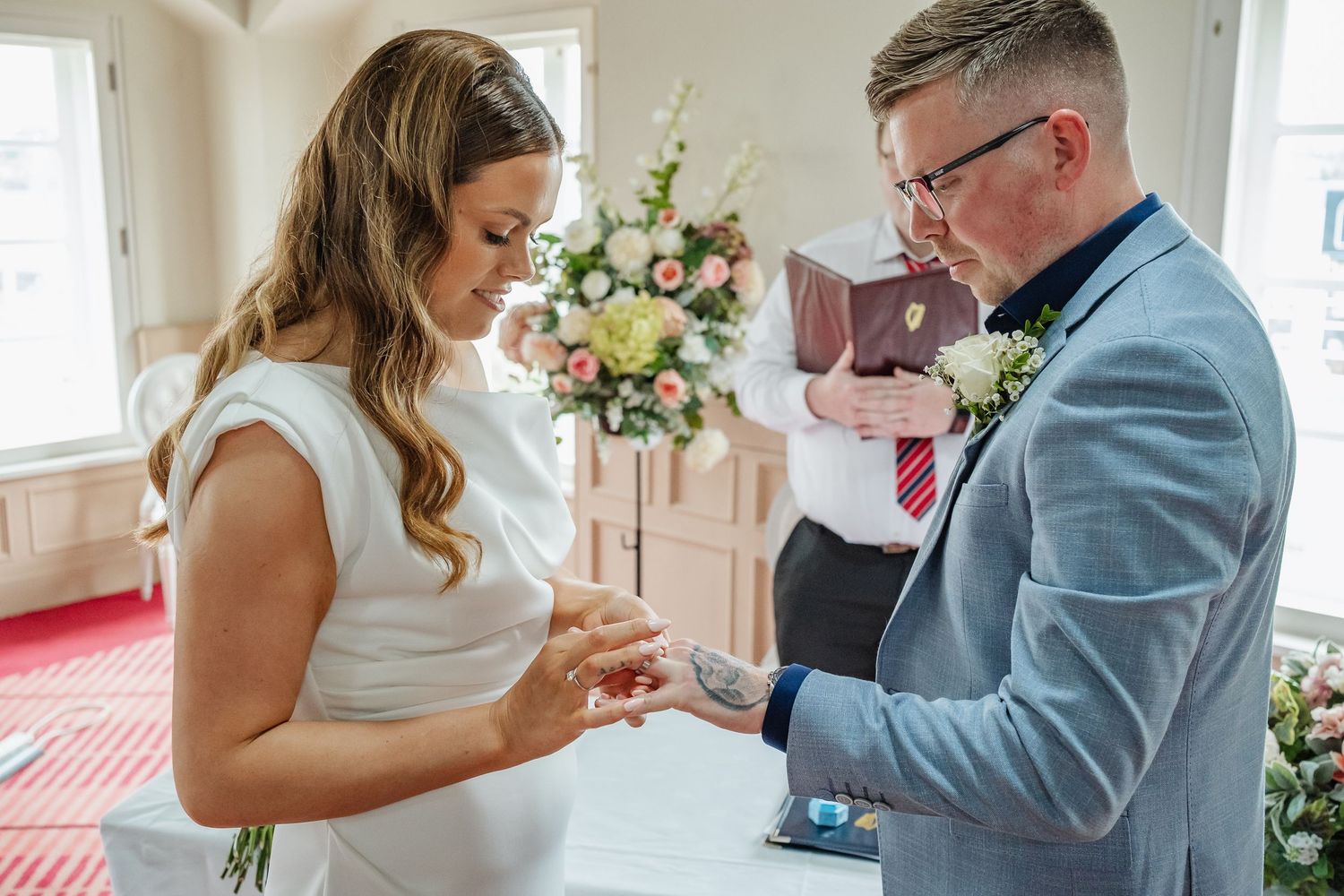 Emotional first look moments between wedding couple in bright indoor setting.