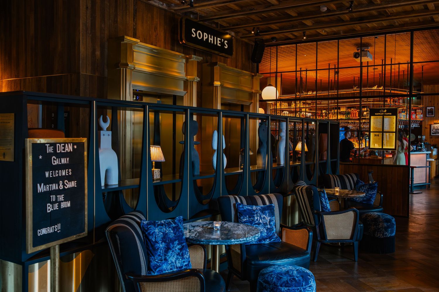 Dark interior panorama of a modern commercial space with blue ambient lighting and reflective surfaces.
