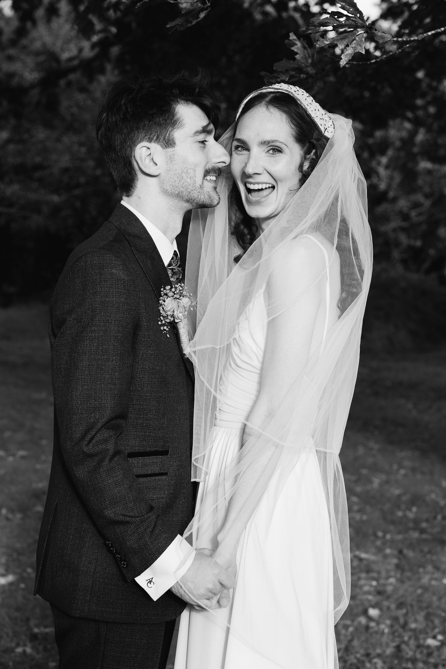 Black and white romantic wedding portraits captured in a natural outdoor setting.