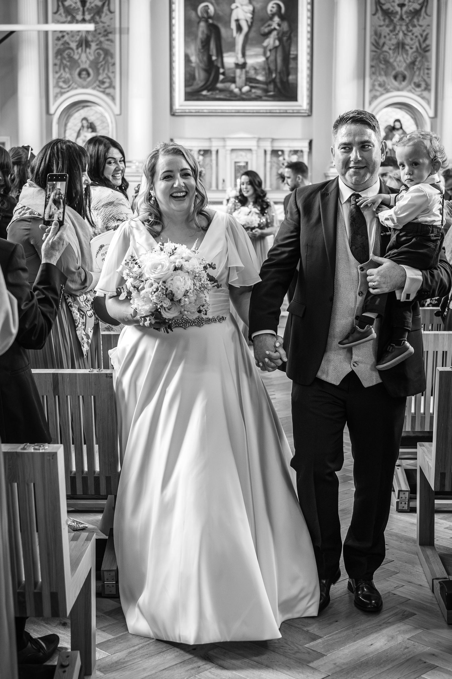 A couple walks down the church aisle together after their wedding ceremony.
