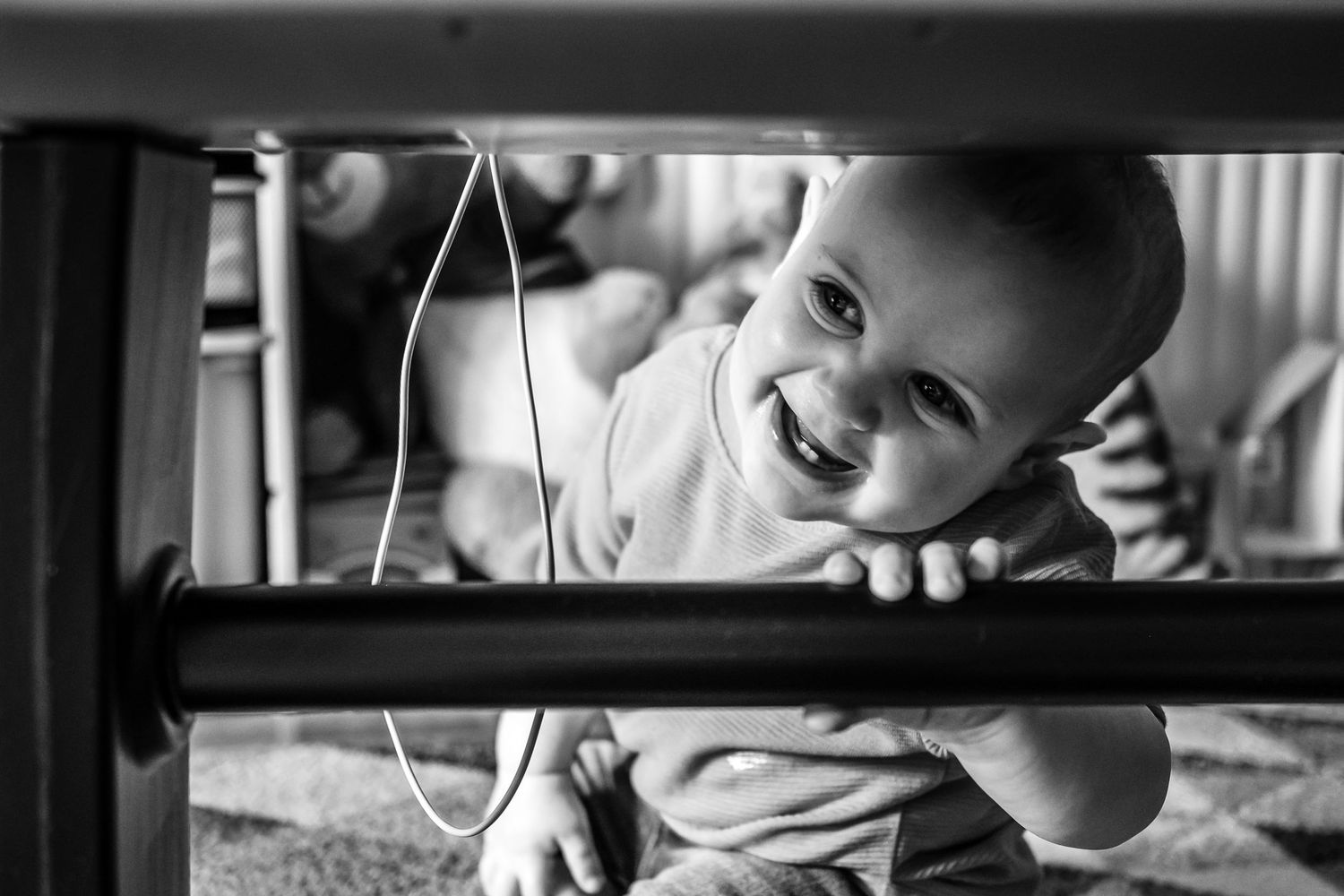 Black and white photo of joyful expression seen through wooden slats.