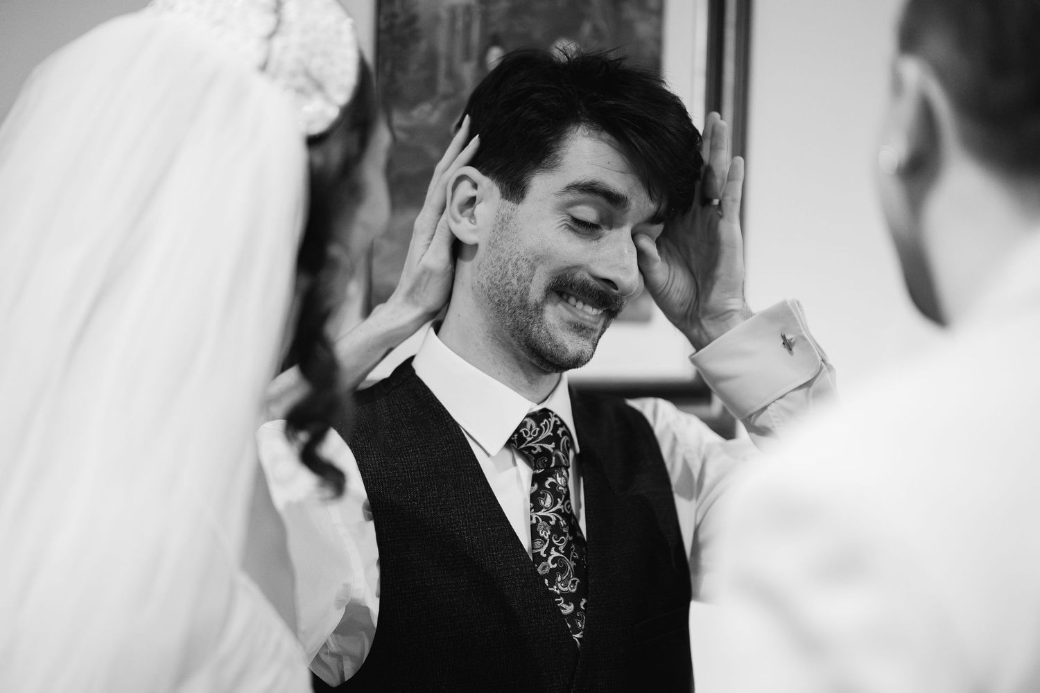 Series of black and white candid wedding photos showing tender moments between couples.