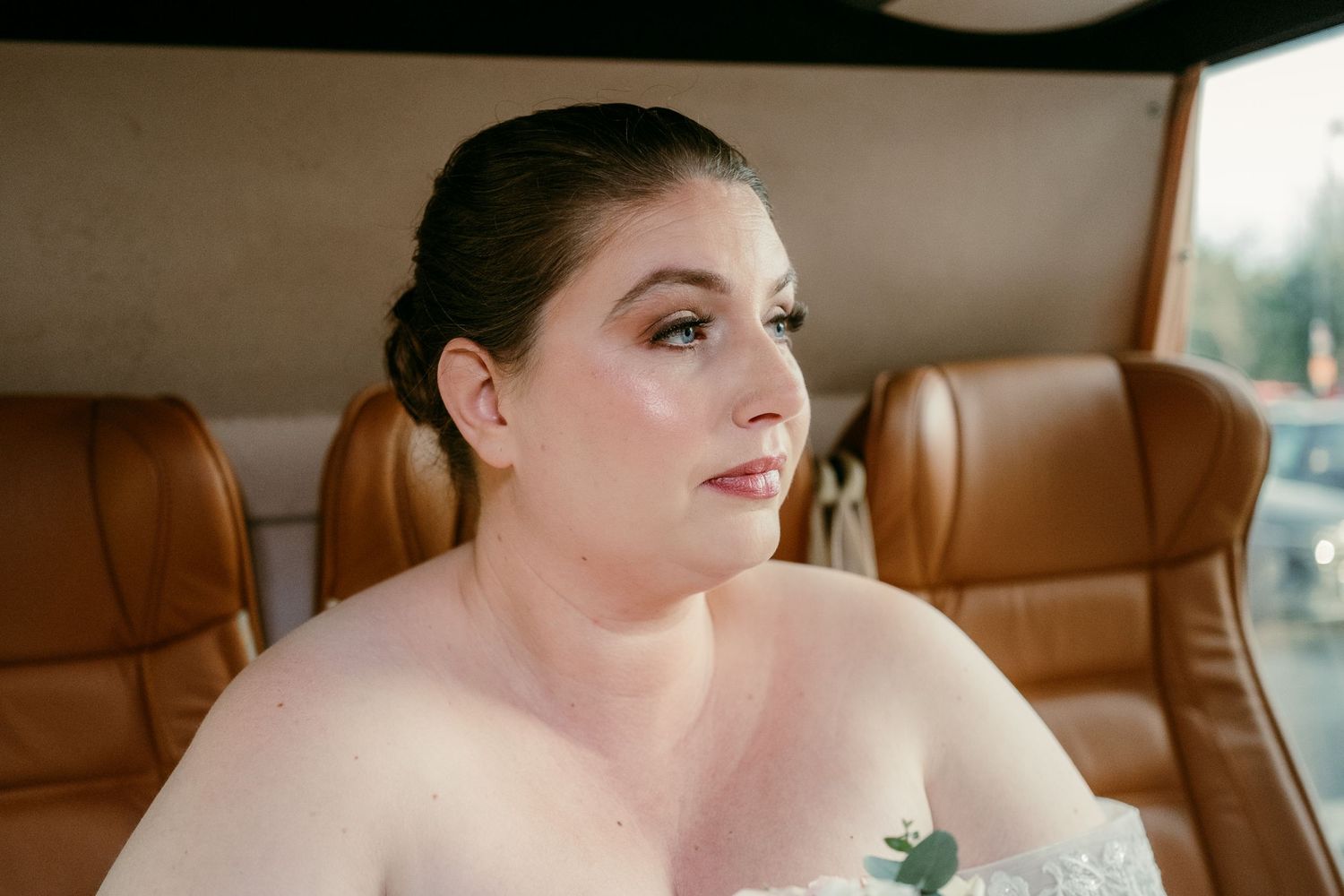 Elegant bridal portrait in luxury vehicle with natural lighting.