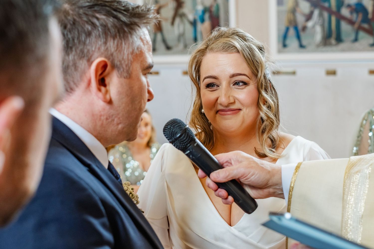 A couple sharing vows during their wedding ceremony with a microphone.