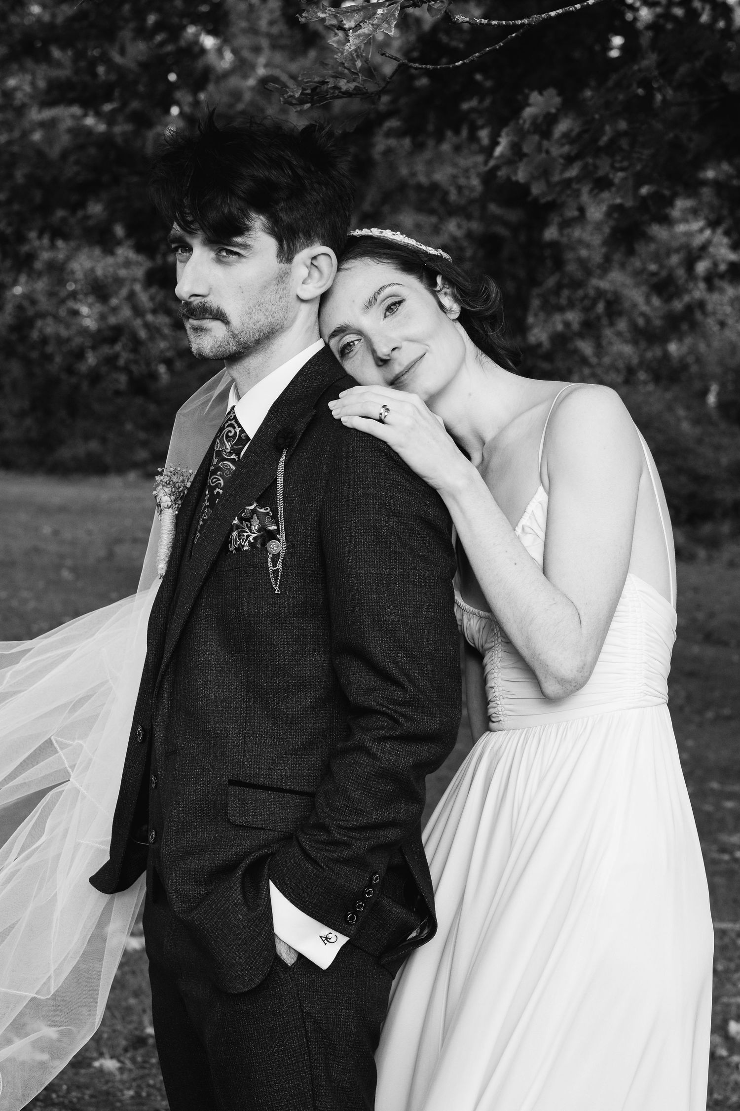 A series of romantic black and white wedding photos showing tender moments between newlyweds outdoors.