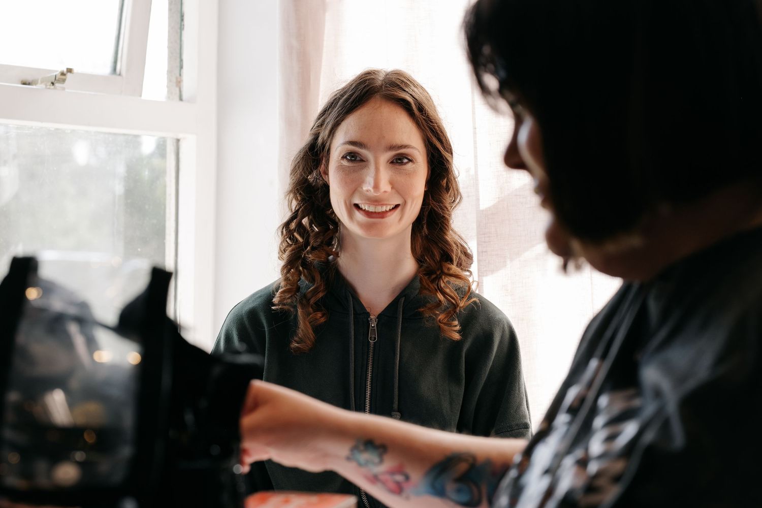 Natural light portraits capture genuine smiles and laughter during wedding morning preparations.