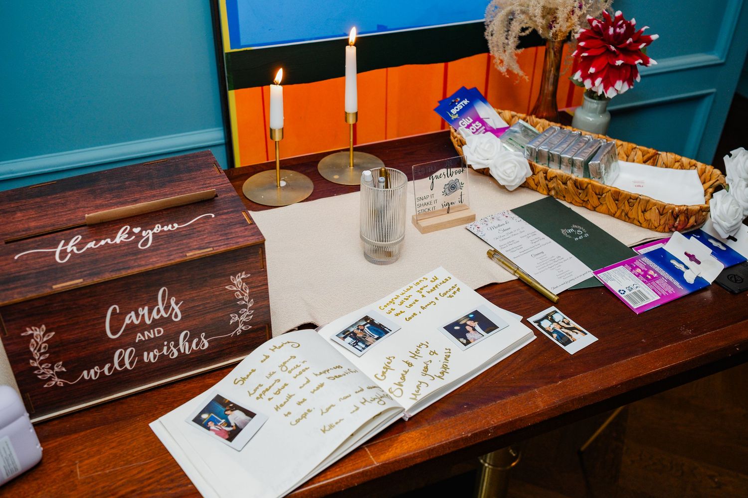 Wedding guest book table with wooden box, candles and handwritten messages.