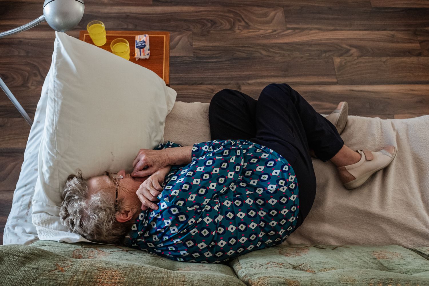 Person resting on couch in patterned clothing.