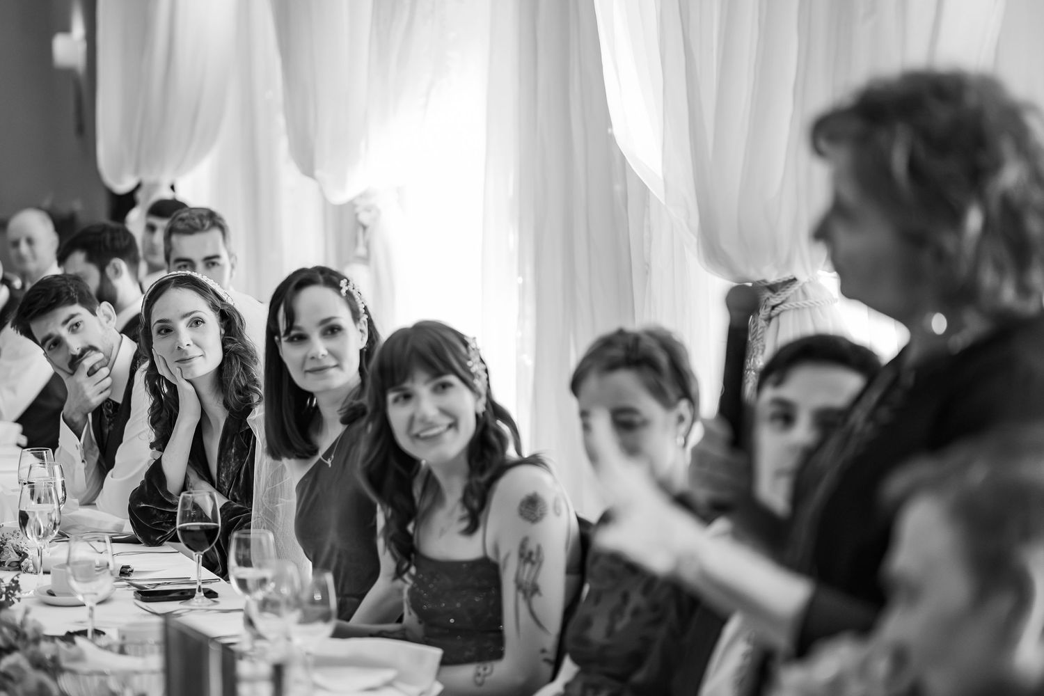 Black and white candid shots of wedding guests enjoying the reception celebration.