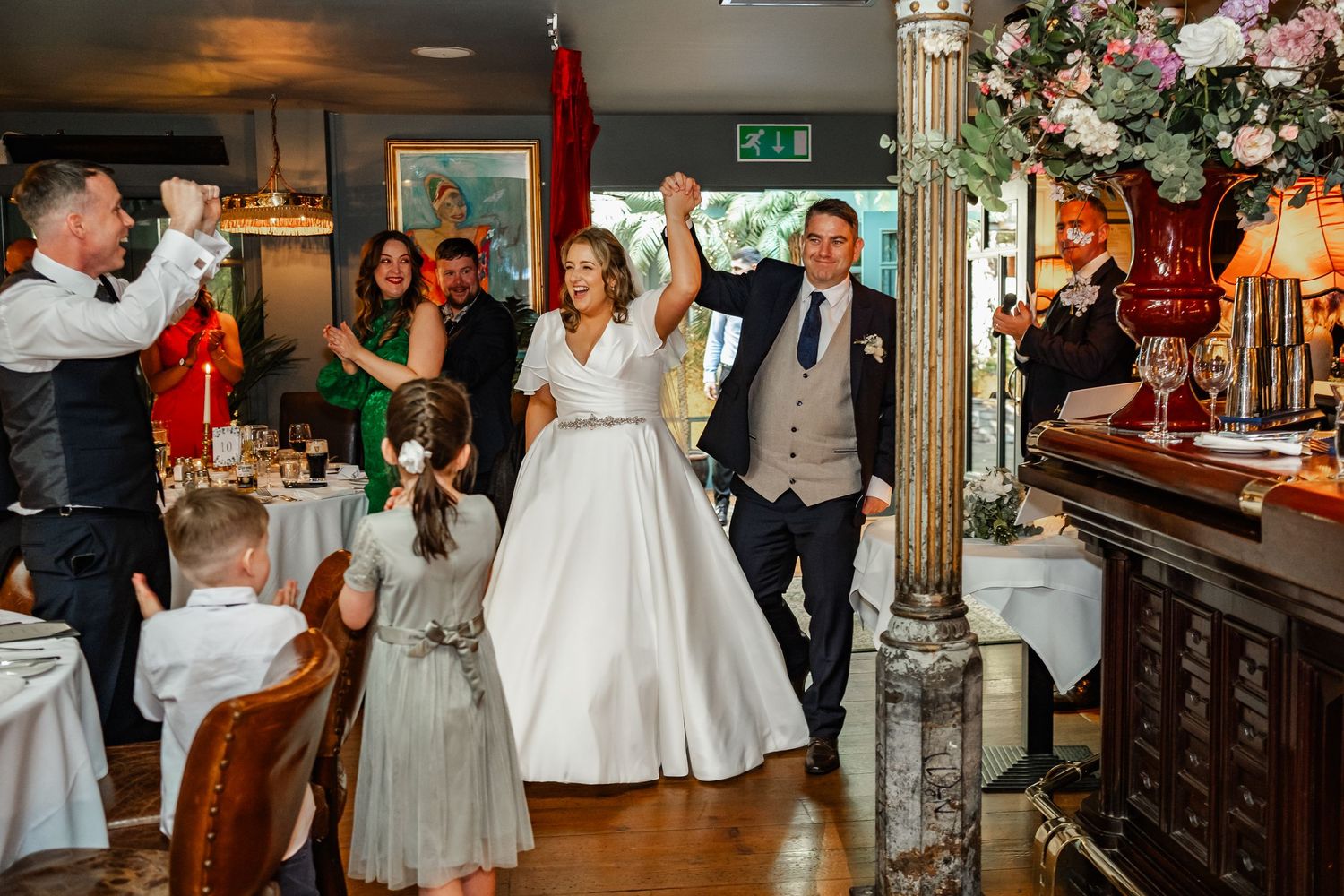 Wedding celebration in a cozy restaurant with floral decorations and festive atmosphere.