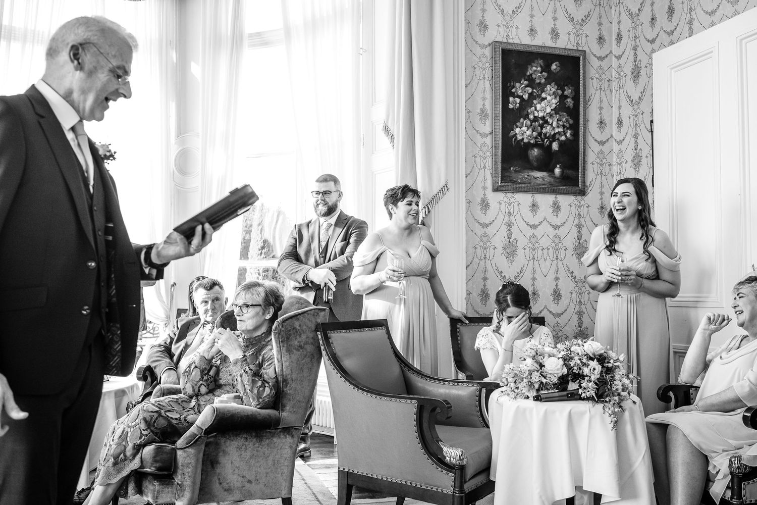 Wedding celebration in a bright elegant room with guests engaged in conversation.
