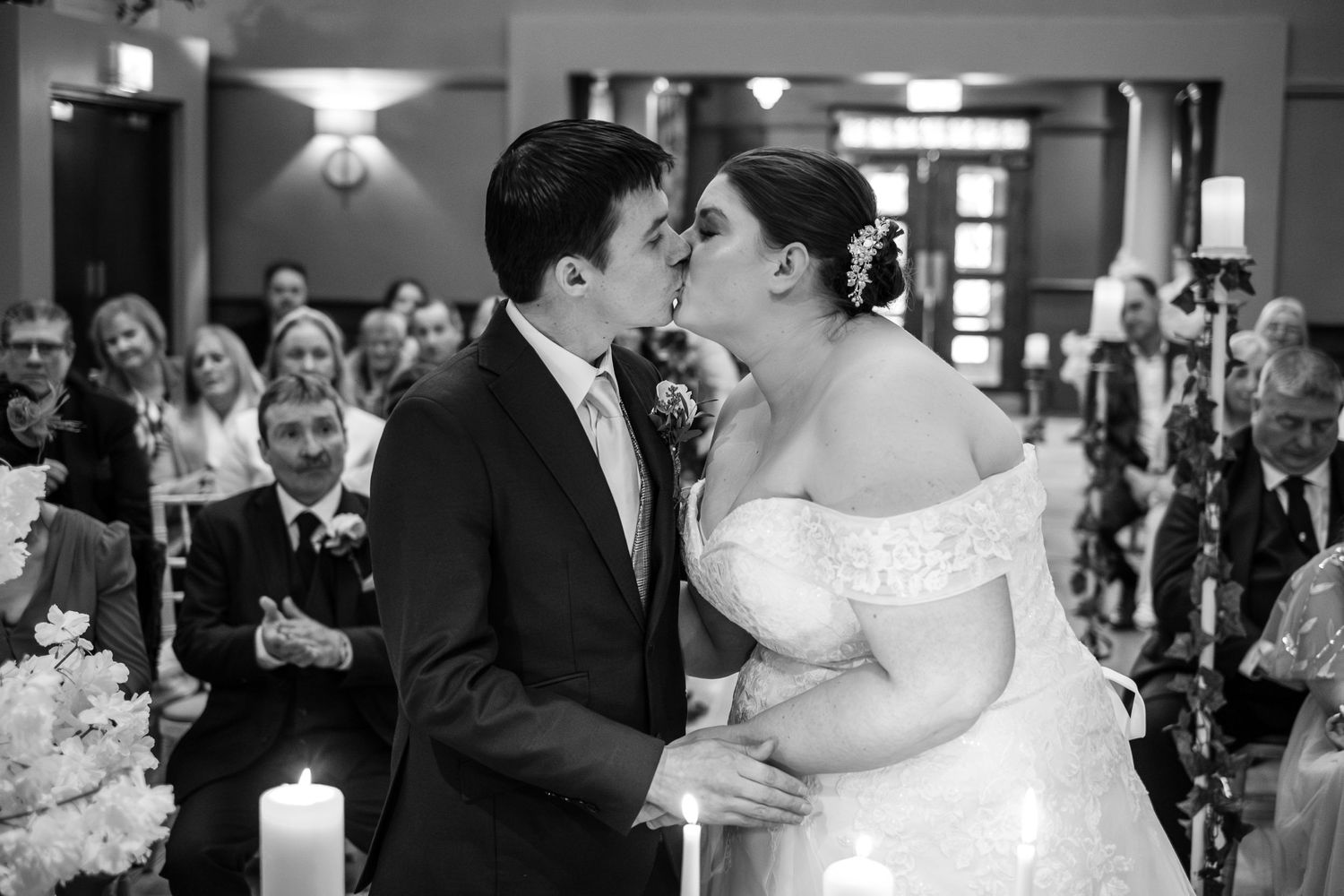 Black and white intimate wedding ceremony moment captured with candlelight.