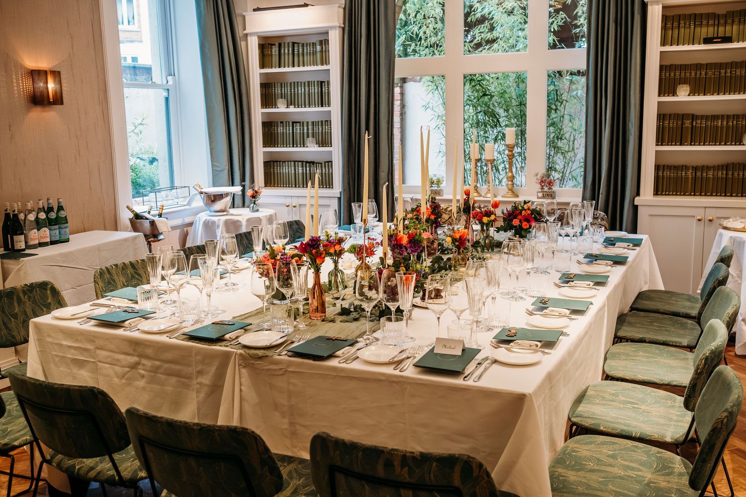 An elegant dining table set with colorful floral arrangements and place settings.