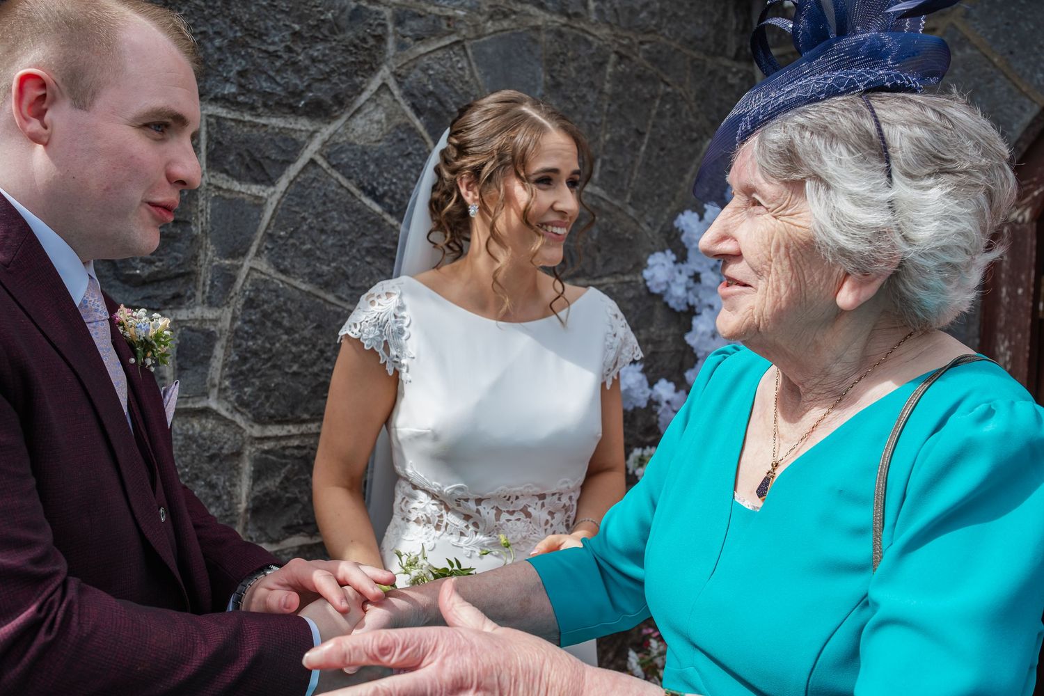 Wedding guests share joyful moments and conversations at outdoor stone venue.