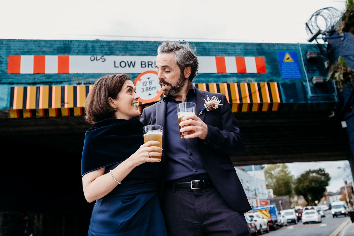 People enjoying drinks outside a blue-painted pub or restaurant.