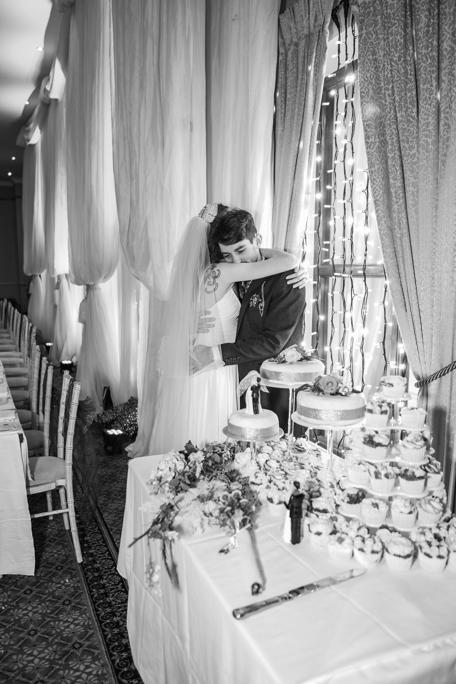 Black and white photos of wedding reception table settings with elegant white draping and floral centerpieces.