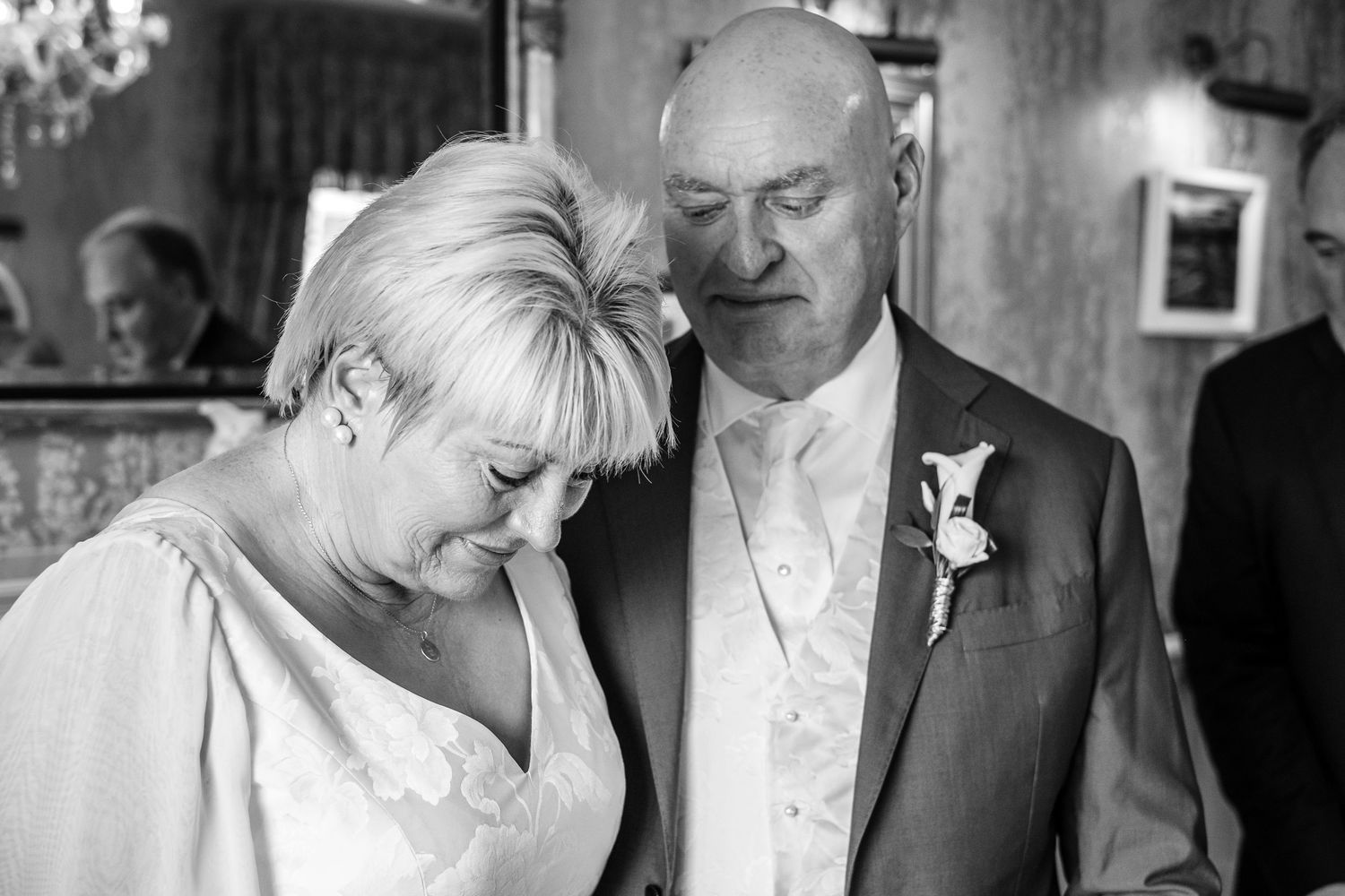 Black and white photo of bride and groom sharing emotional wedding vows during ceremony.