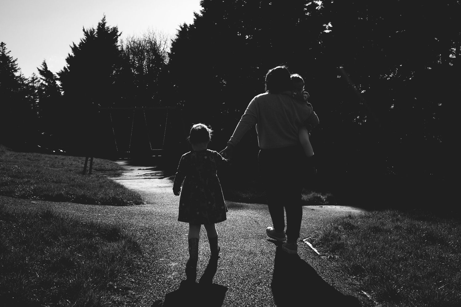 A silhouetted pair walking together on a winding path at dusk.