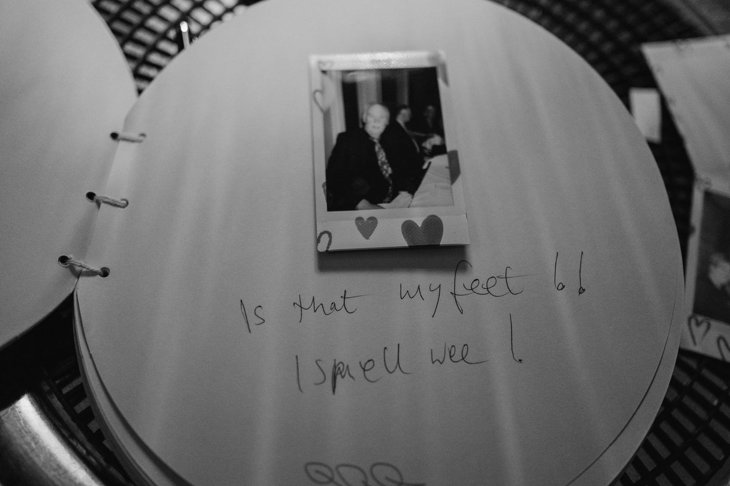 Black and white polaroid photo with handwritten text and heart decorations in a notebook.