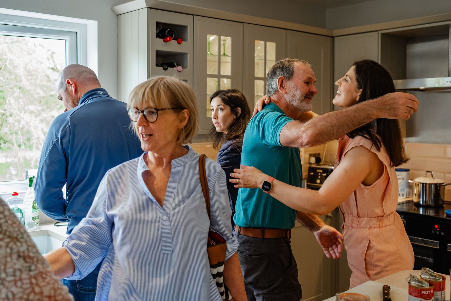 Casual gathering of people interacting in a modern kitchen space.