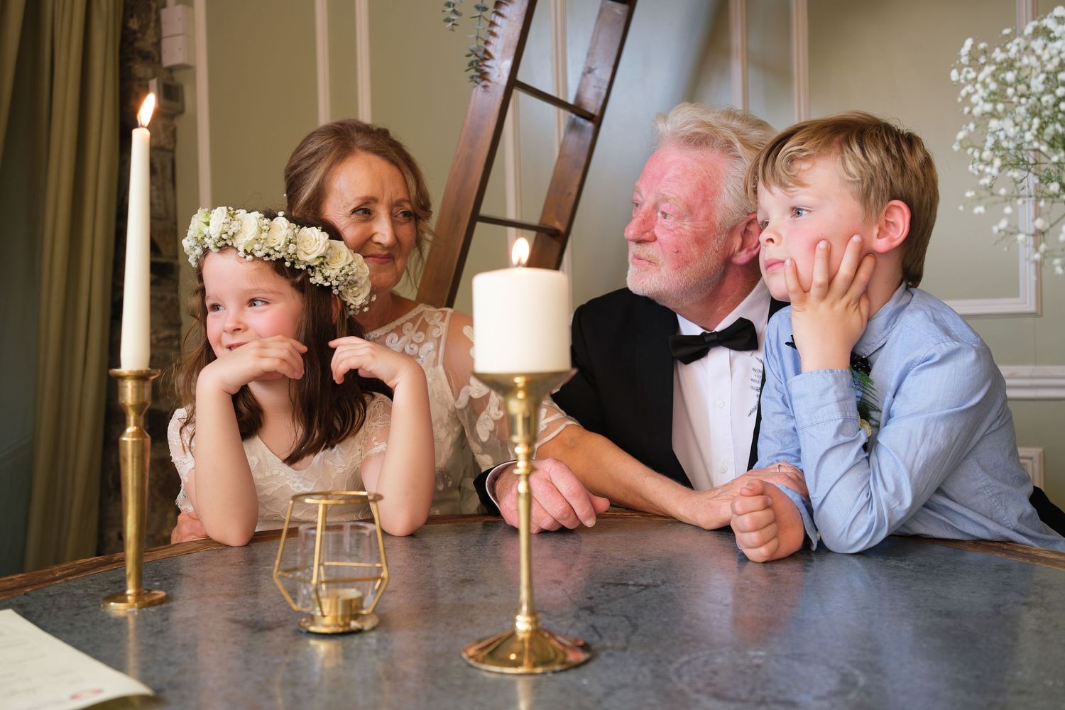 Wedding guests enjoying a candid moment at an elegant reception table with gold candelabra.