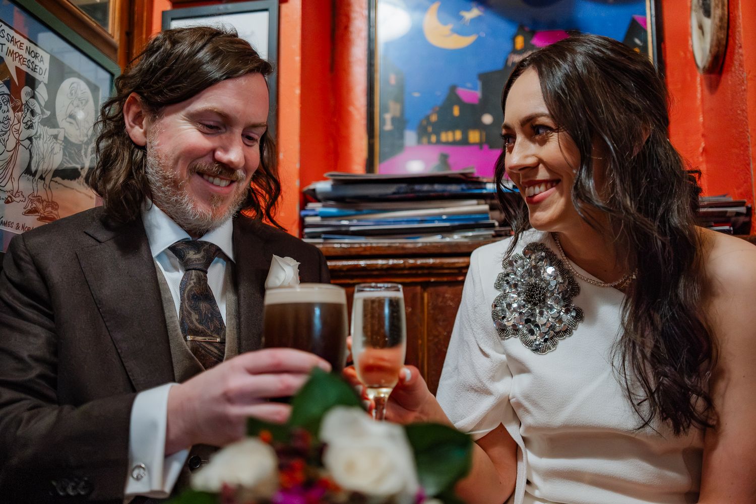 Wedding reception in a cozy venue with colorful moon and star murals on orange walls.