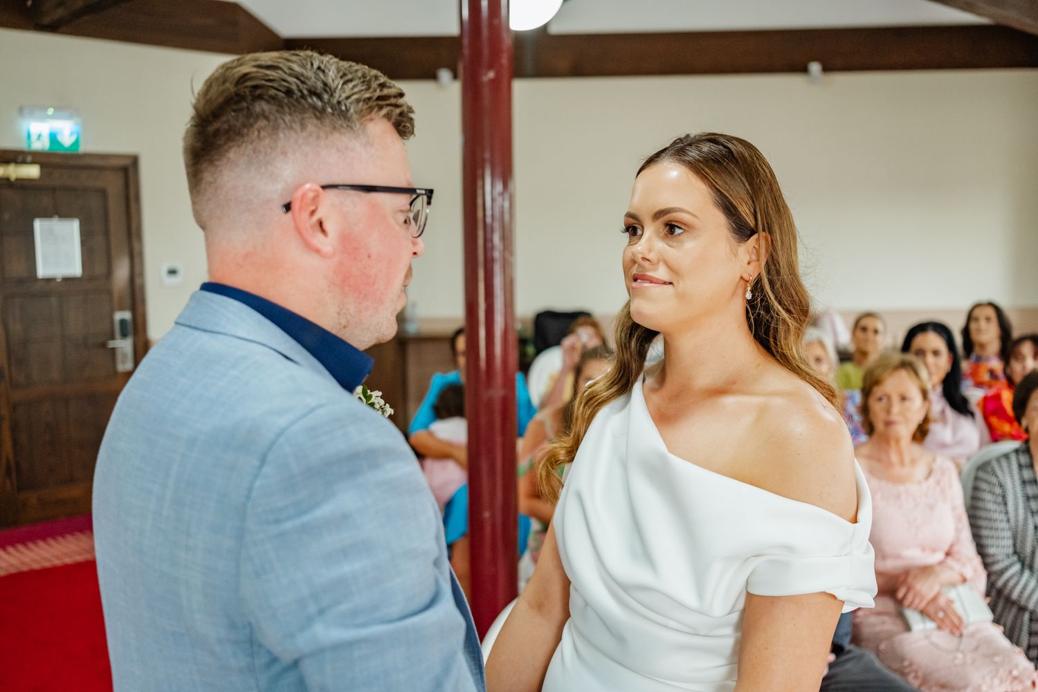 Intimate wedding ceremony moment with light blue suit and white dress.