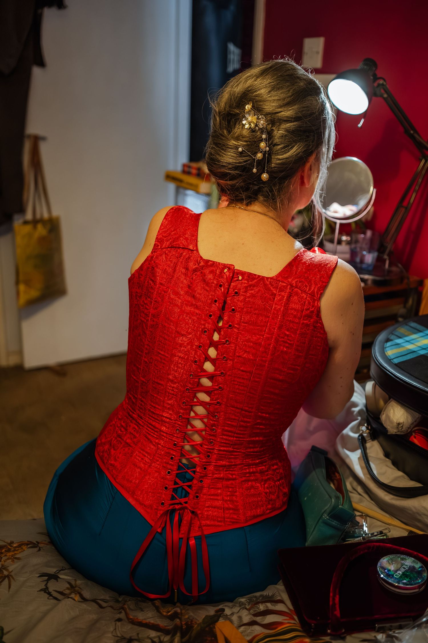 Back view of someone wearing red corset with intricate lace-up detail.