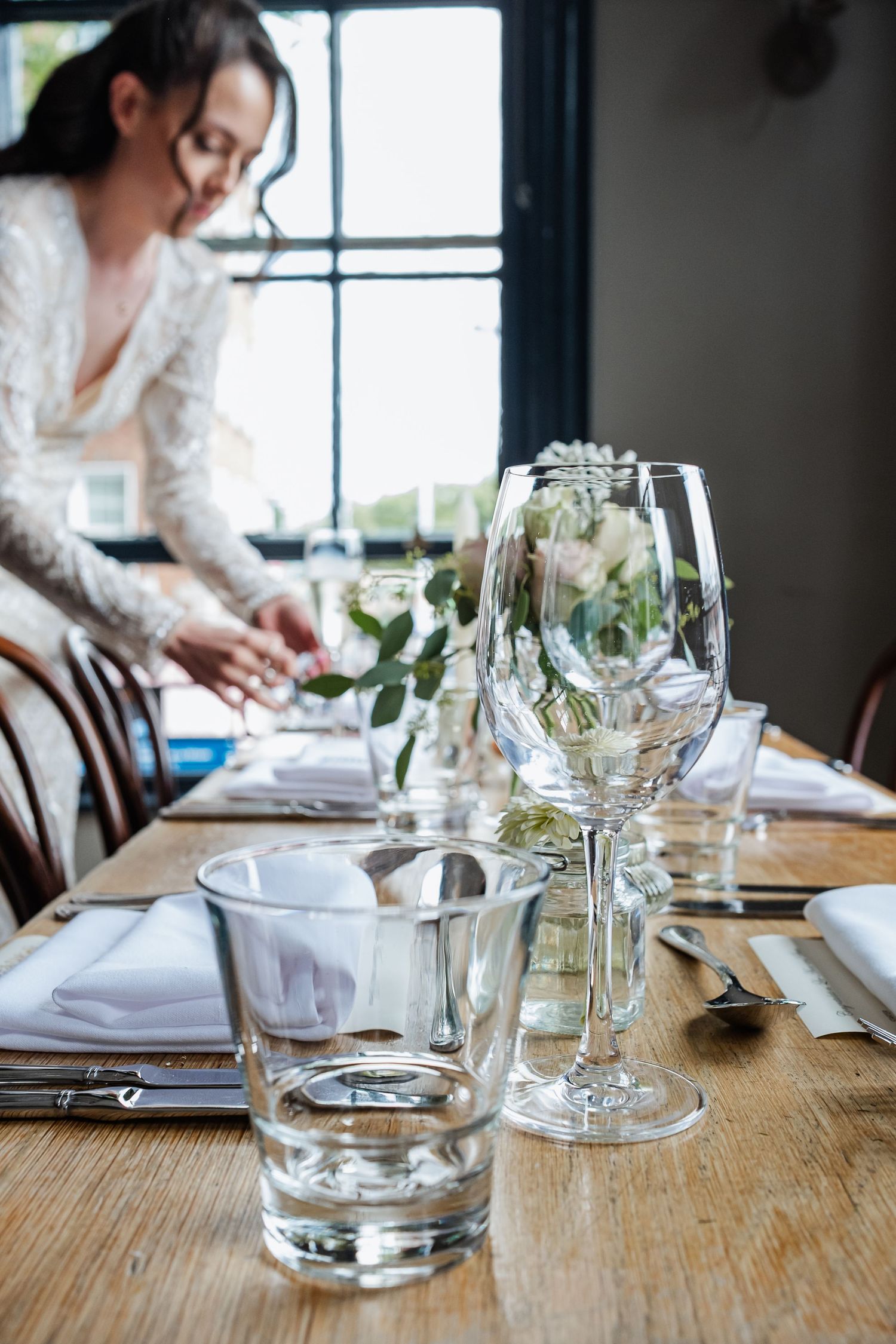 Place settings and glassware arranged on a rustic wooden table for an elegant dining experience.