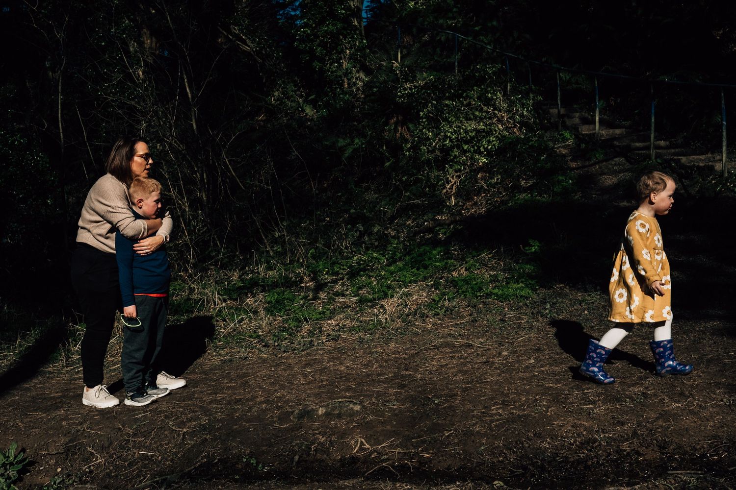 A family walking along a wooded dirt path during an outdoor adventure.