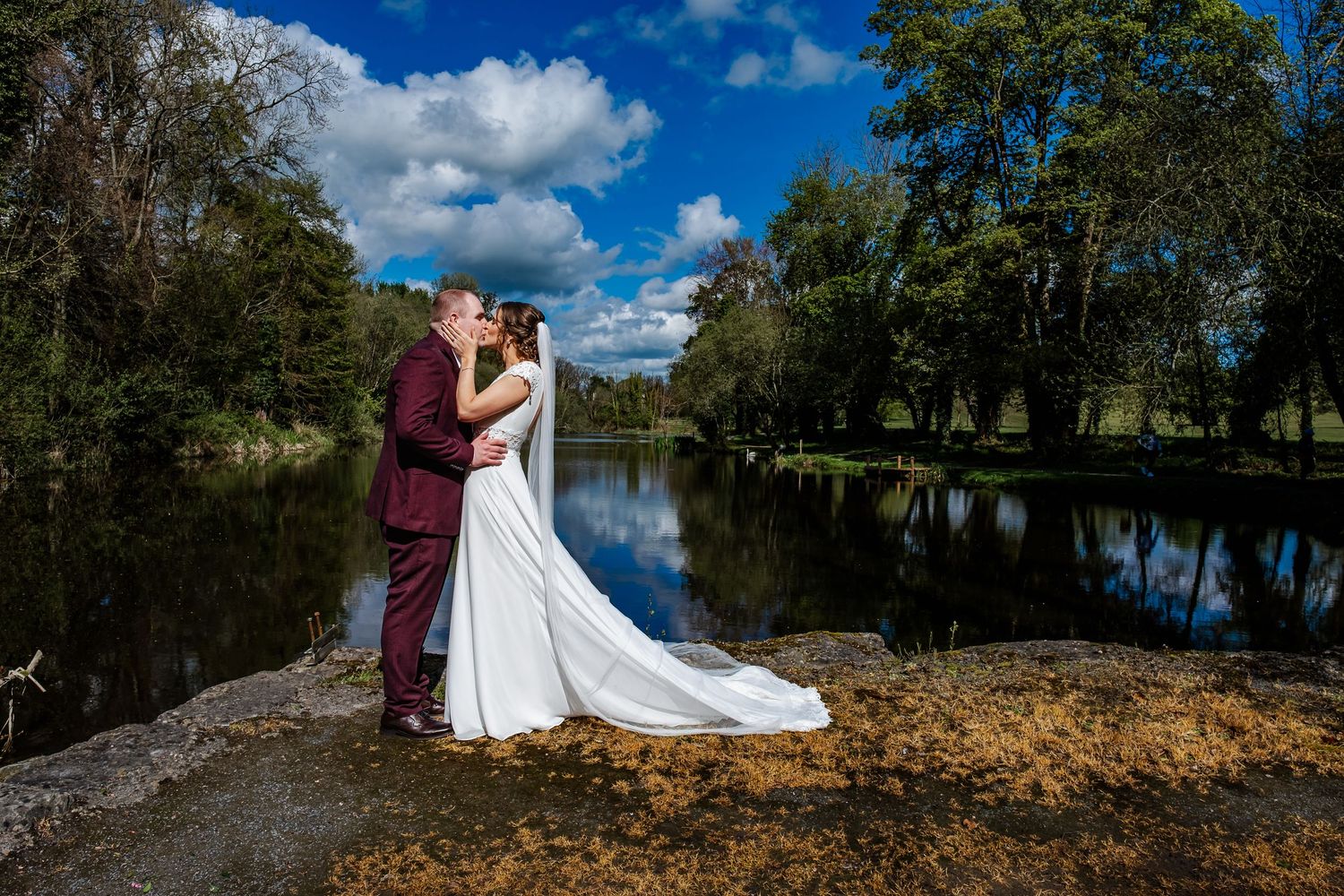 Wedding portraits against natural landscape with blue skies and dramatic clouds.