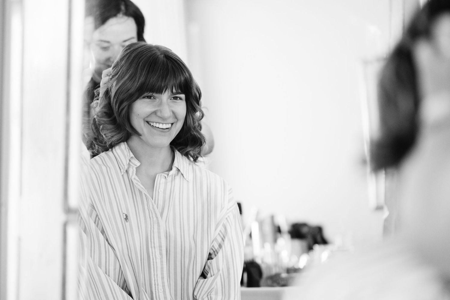 Candid black and white photos showing joyful expressions during wedding preparations.