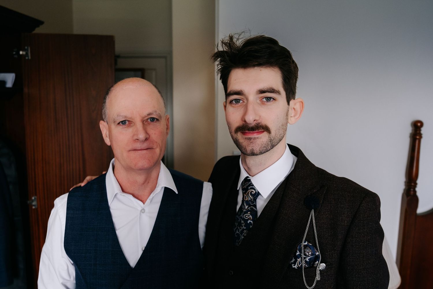 Formal group photo of men wearing suits and dress shirts against a neutral background.