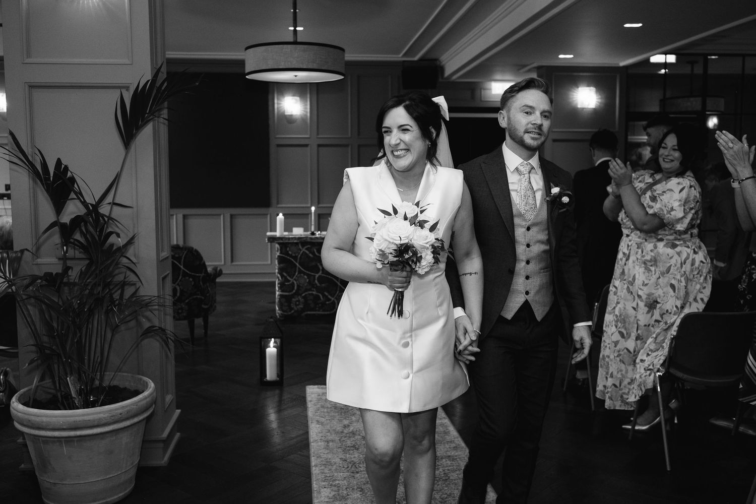 Indoor wedding venue space with decorative lighting and guests celebrating.