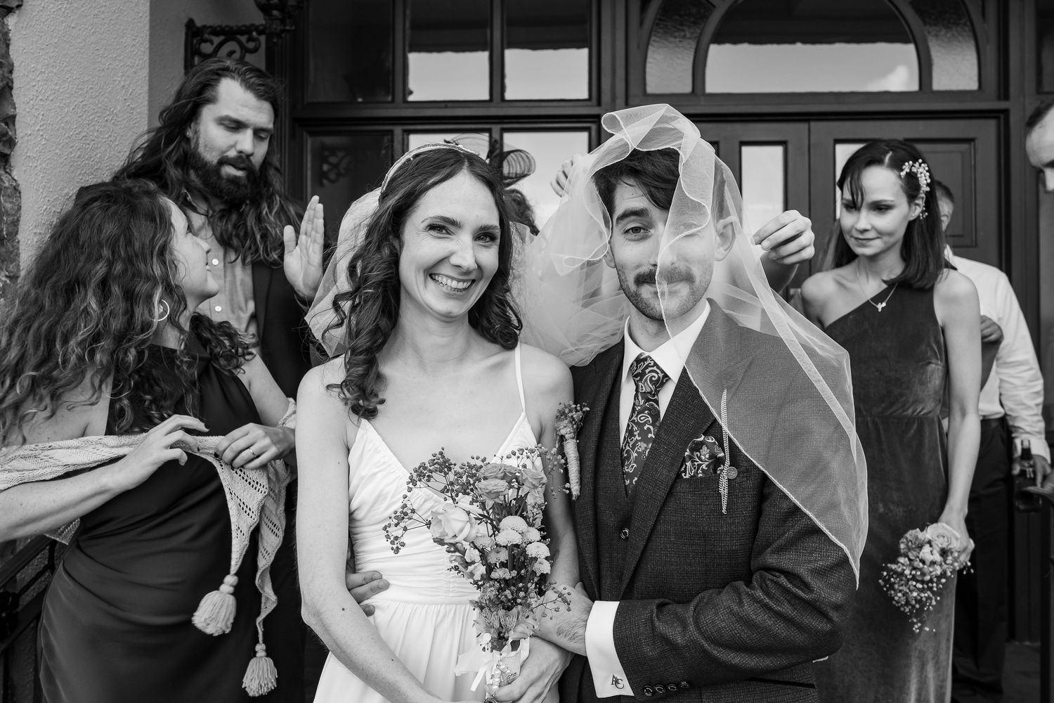 Black and white wedding photos arranged in a filmstrip style collage showing candid moments and celebrations.