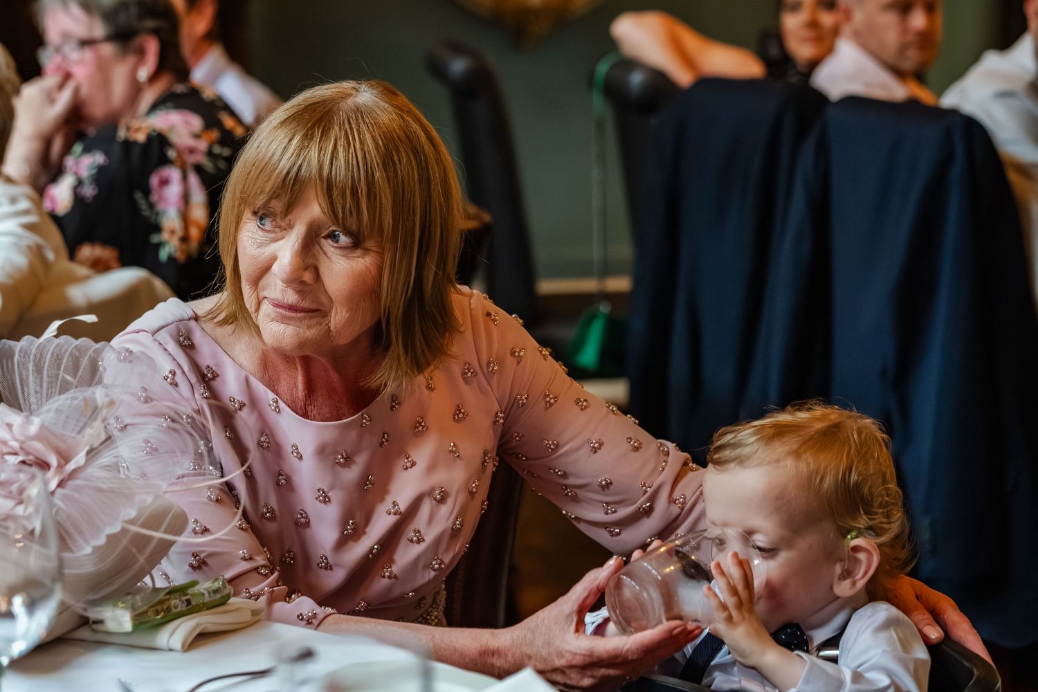 Family moment captured during wedding reception as guests enjoy their meal.