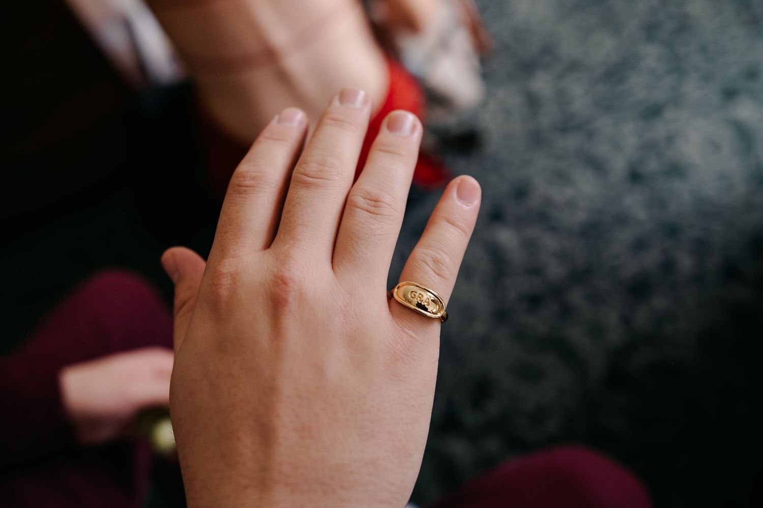 Series of hands showing off a gold wedding ring against a dark background.
