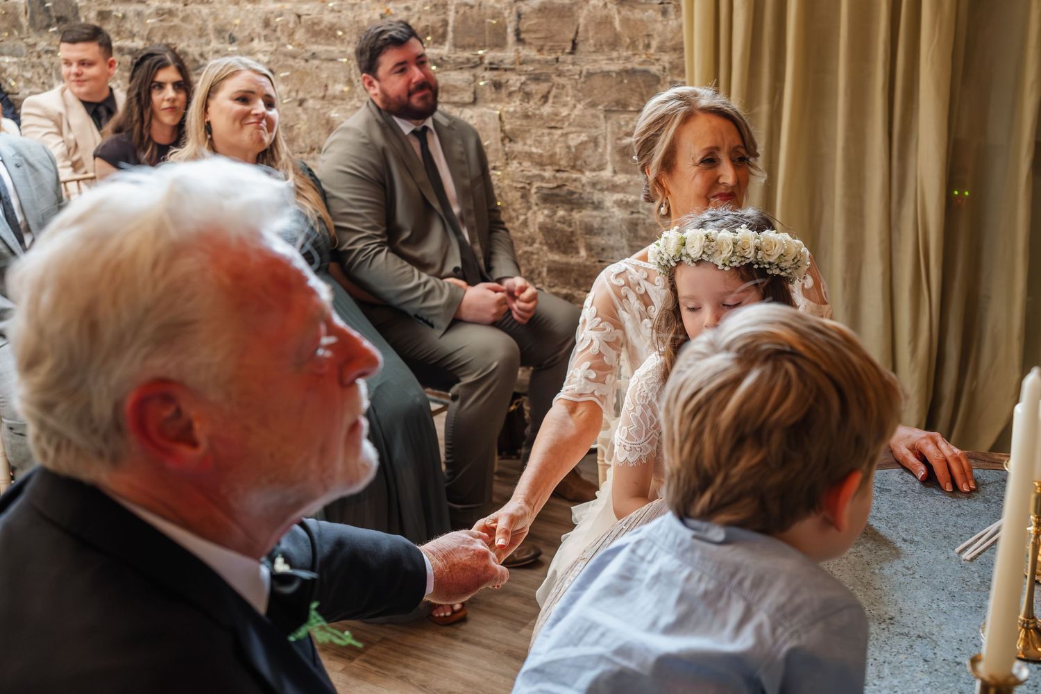 Emotional embrace during wedding celebration with decorative lighting.