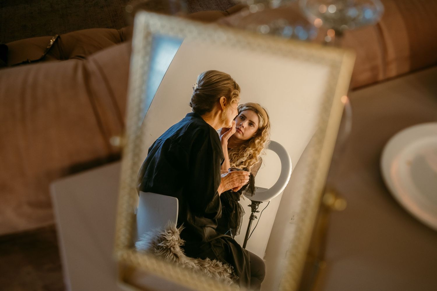 Reflection of a romantic couple in an ornate mirror frame.