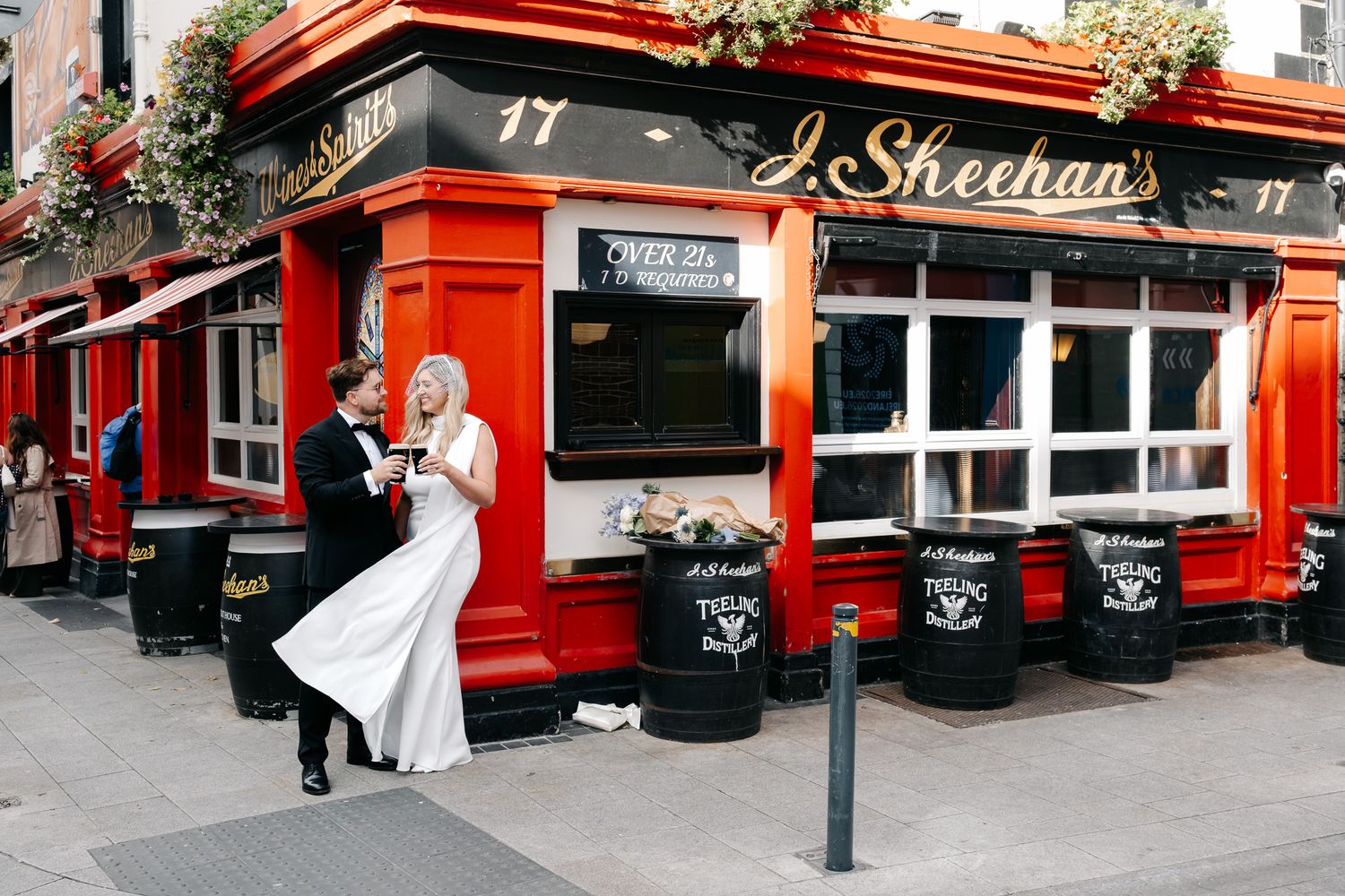 Bride and groom share a romantic moment outside J. Sheehan's red pub, number 17, on their wedding day.