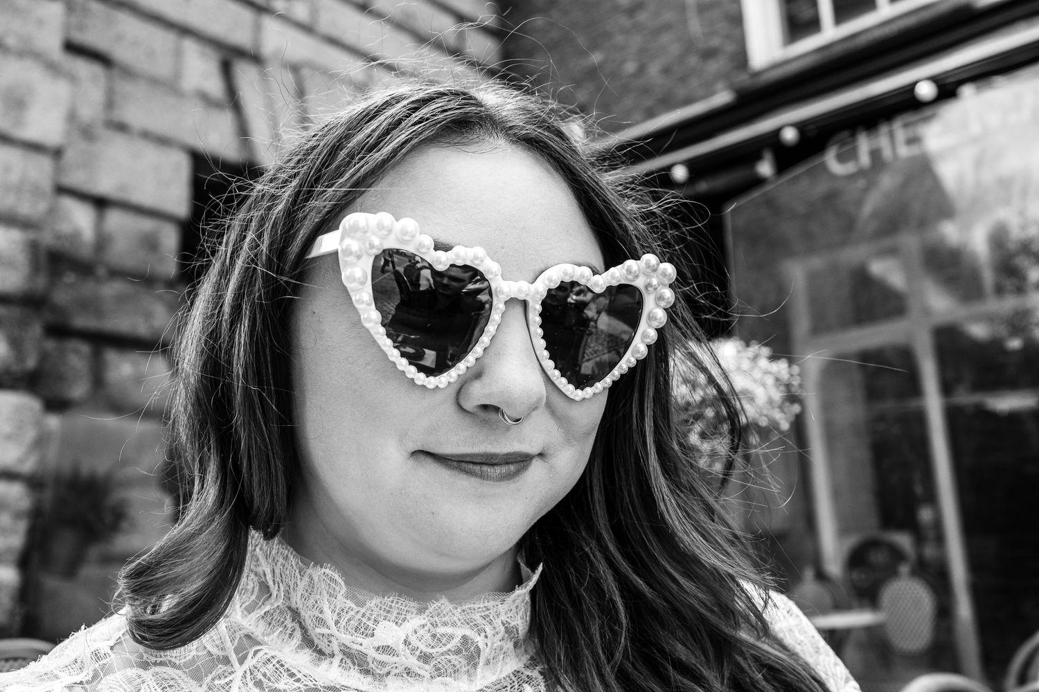 Close-up wedding photography with vintage-style sunglasses and urban setting.
