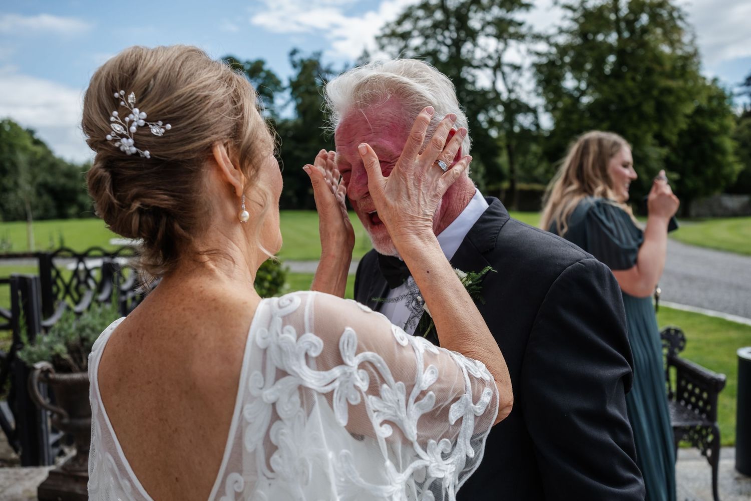An emotional moment between two people on a balcony during a wedding celebration.