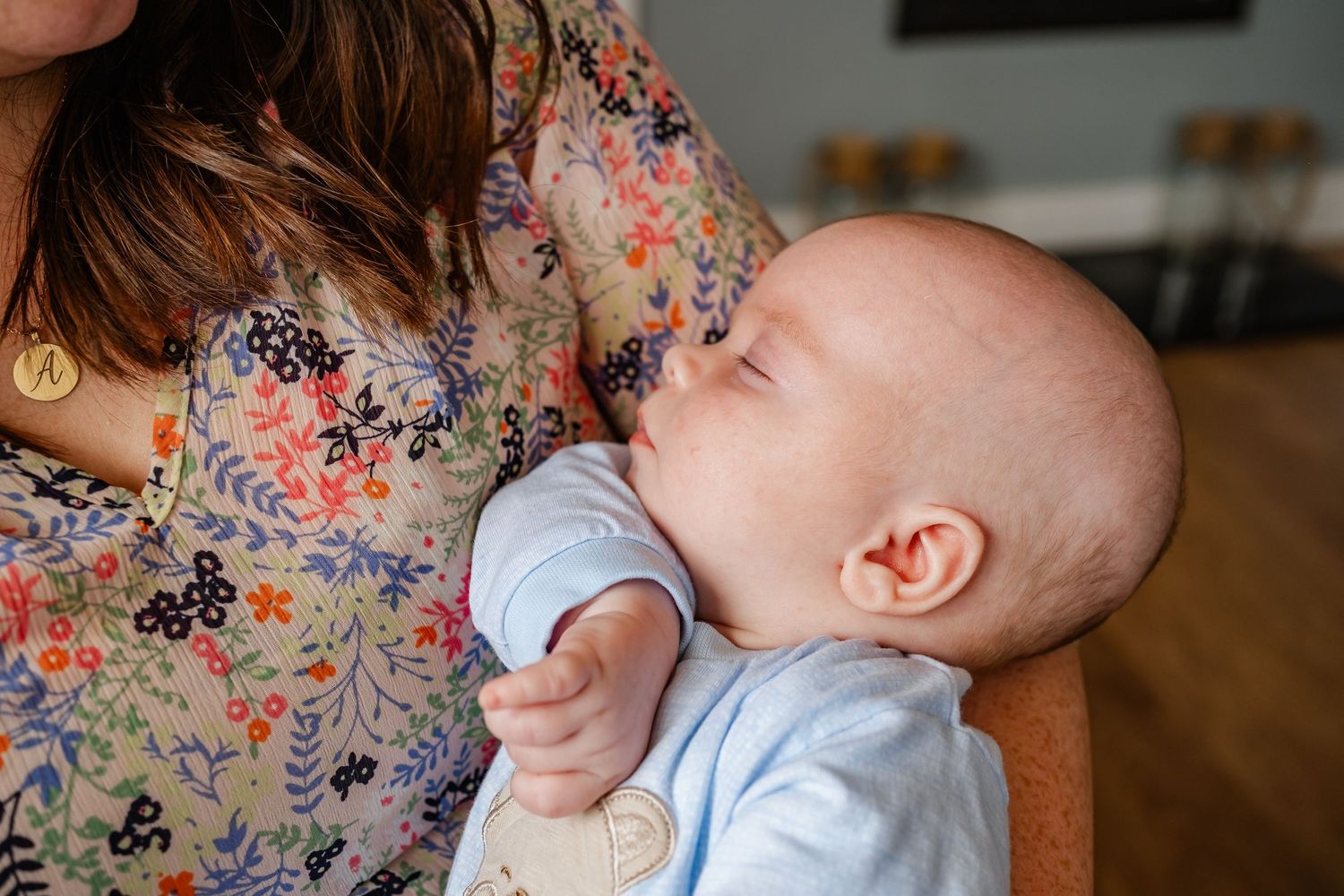 Baby drinking from bottle while being held.