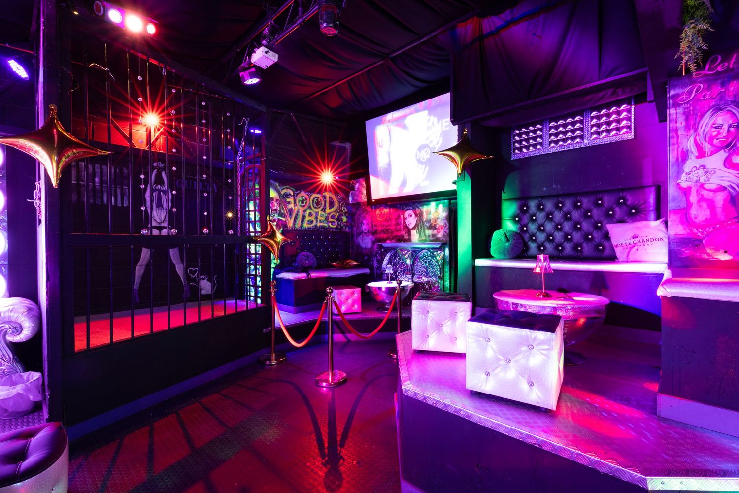 Panoramic view of adult club interior with purple and pink LED lighting at Penthouse Playrooms Dunstable, showing bar and lounge areas