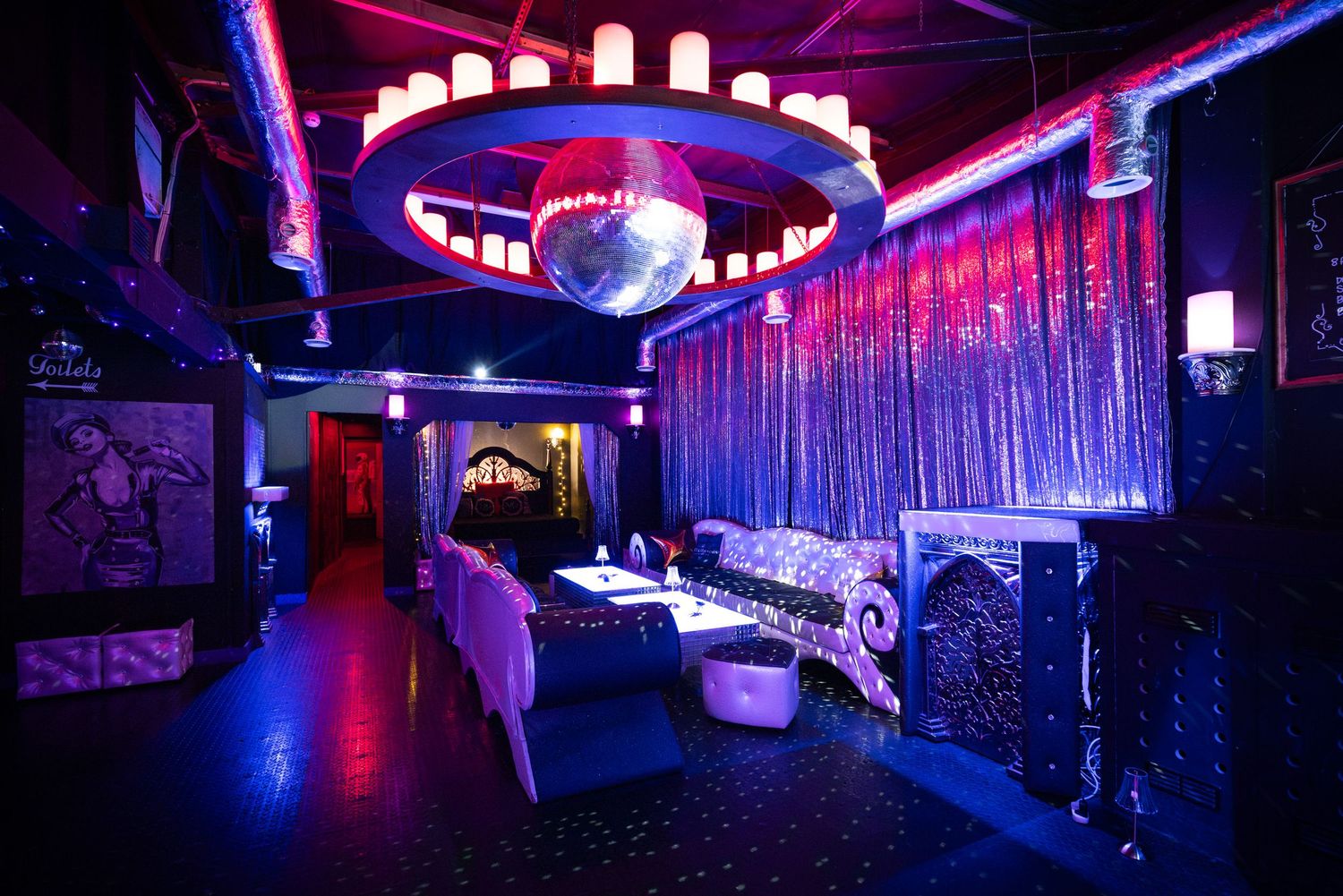 Modern adult club interior with neon lighting and LED ceiling at Penthouse Playrooms Dunstable, with plush lounge seating in purple tones